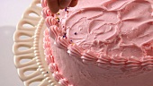 Sprinkling strawberry cream cake with hundreds and thousands