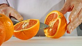 Orange in Schnitzen schneiden
