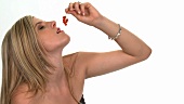 Blonde Frau isst rote Johannisbeeren