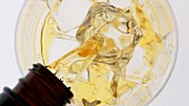 Whisky in ein Glas mit Eiswürfeln gießen