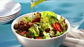 Drizzling mixed salad with olive oil