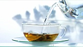 Schwarzen Tee zubereiten: Teebeutel mit heißem Wasser übergiessen