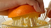 Orangenhälfte auspressen