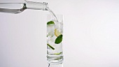 Ein Glas Mineralwasser mit Minzblättern und Limettenscheiben