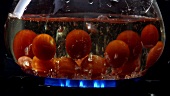 Dropping tomatoes into boiling water
