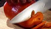 Cutting a whole red pepper into rings
