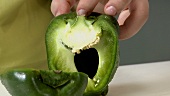 Halving and deseeding a green pepper