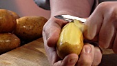 Eine Kartoffel schälen