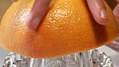 Squeezing pink grapefruit (close-up)