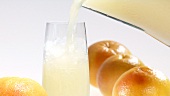 Grapefruitsaft in ein Glas mit Crushed Ice gießen