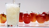 Pouring apple juice into a glass of crushed ice