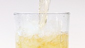 Apfelsaft in ein Glas mit Crushed Ice gießen (Close Up)