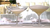 Champagne being poured into two glasses