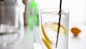 A gin and tonic being stirred