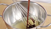 Pouring melted chocolate coating into egg mixture