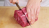 Cutting a thick slice from a shoulder of beef