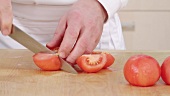 Peeled tomatoes being quartered and deseeded