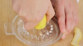 A lemon half being pressed