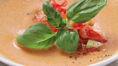 Gazpacho mit Basilikum und Gemüsewürfeln garniert