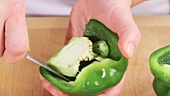 A green pepper being deseeded