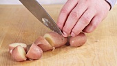 Potatoes cooked in their skins being chopped