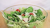 Hähnchen-Orzo-Salat mit frisch gehobeltem Parmesan bestreuen