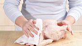 Chicken being patted dry