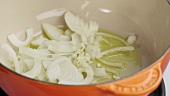 Onions being added to a oil in a saucepan