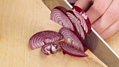 Red onions being cut into half rings