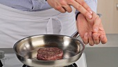 Testing the doneness of a fillet steak using the finger method (medium rare)