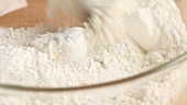 Baking powder being added to flour
