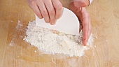 Chopping dough ingredients together using a scraper