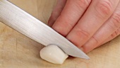 A garlic clove being halved