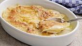 Potato gratin in a baking dish with a spoon