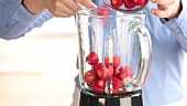Strawberries being added to a blender