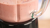 A strawberry shake being made in a blender