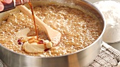 Peanut butter fudge being made: peanut butter being stirred into milk caramel