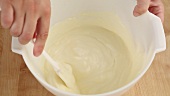 Whipped cream being stirred into a cream cheese and orange mixture