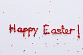 The words 'Happy Easter' in red icing with sprinkles