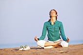Junge Frau macht Yoga am Strand
