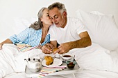 Älteres Ehepaar frühstückt im Bett