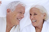 Elderly couple in bathrobes with towel