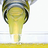 Pouring orangeade into glass (close-up)