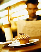 Muffin and coffee in restaurant, man reading newspaper
