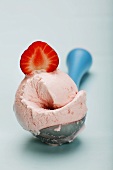 Scoop of strawberry ice cream on ice cream disher, close-up