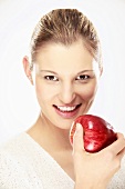 Young woman holding apple, close-up, portrait
