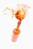 Grapefruit juice splashing out of bottle