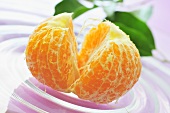 Peeled mandarin orange on glass plate