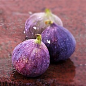 Three fresh figs on wet brick