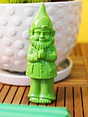 Green garden gnome in front of flowerpot